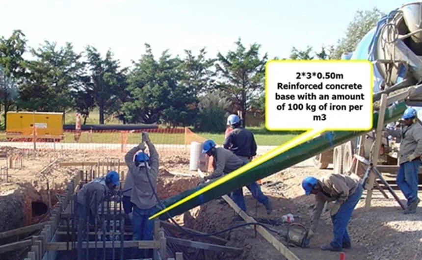 The image shows workers constructing the concrete base.